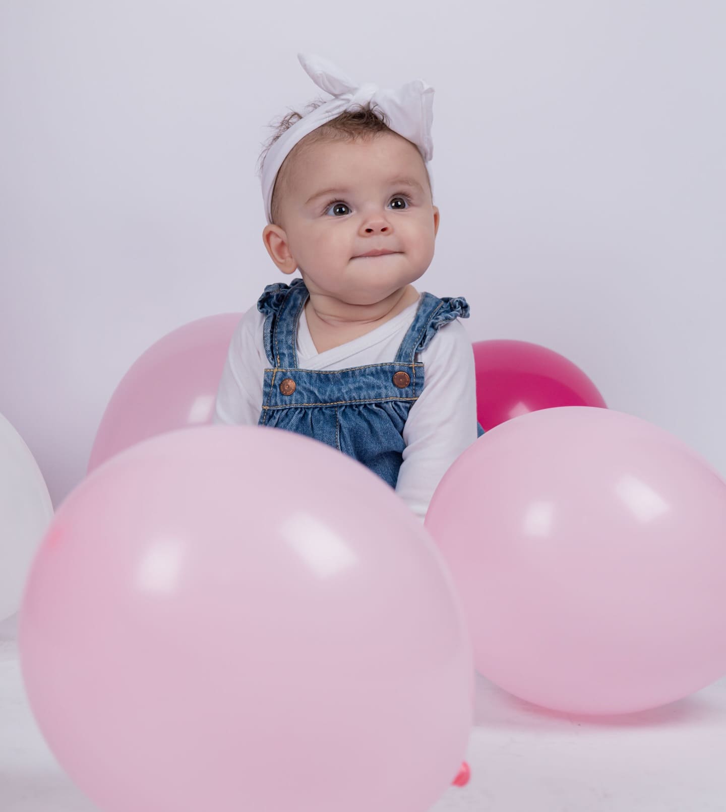 Bebé rodeado de balões durante uma festa de família